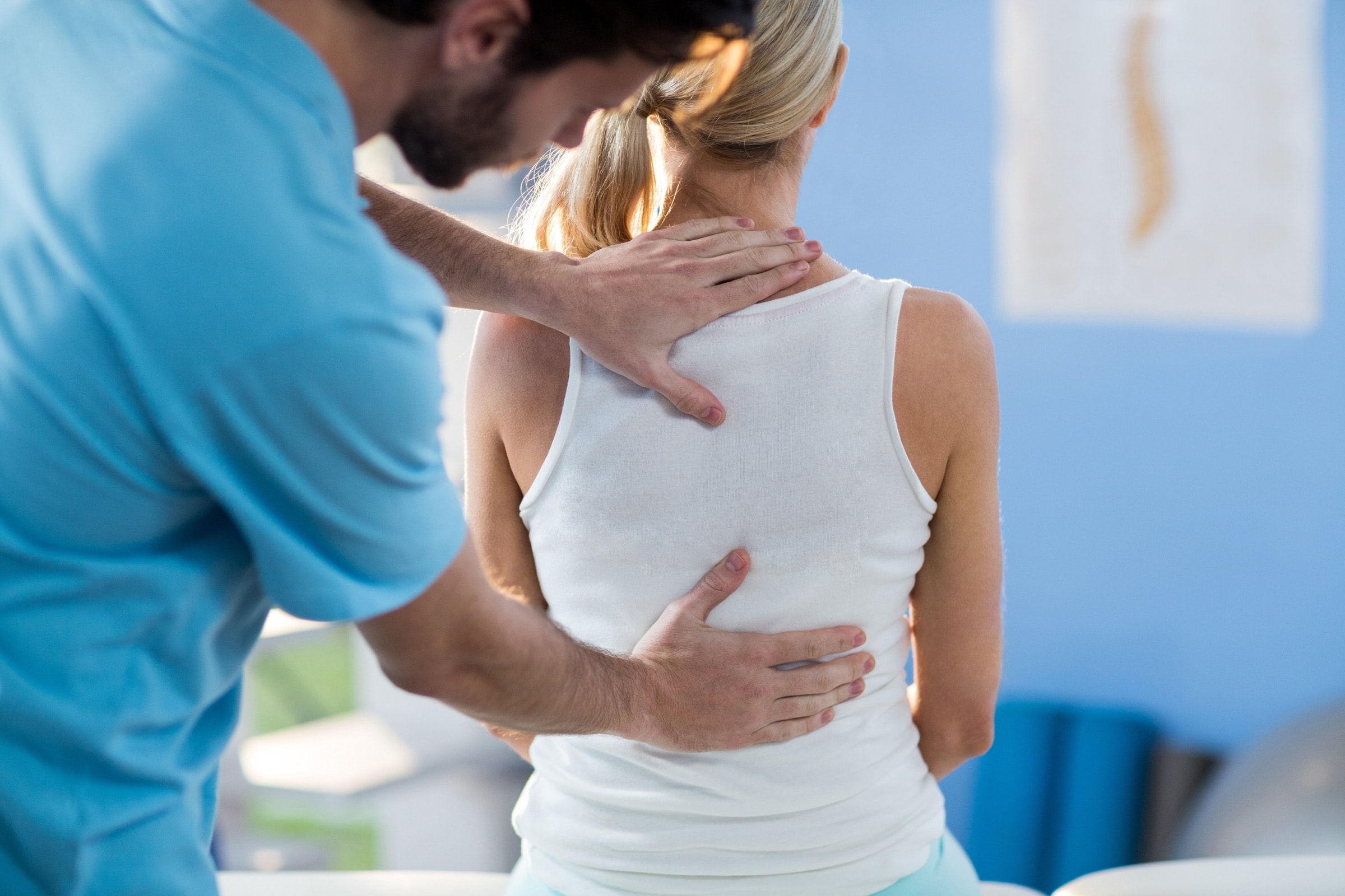 Male therapist with his hands on a woman's back