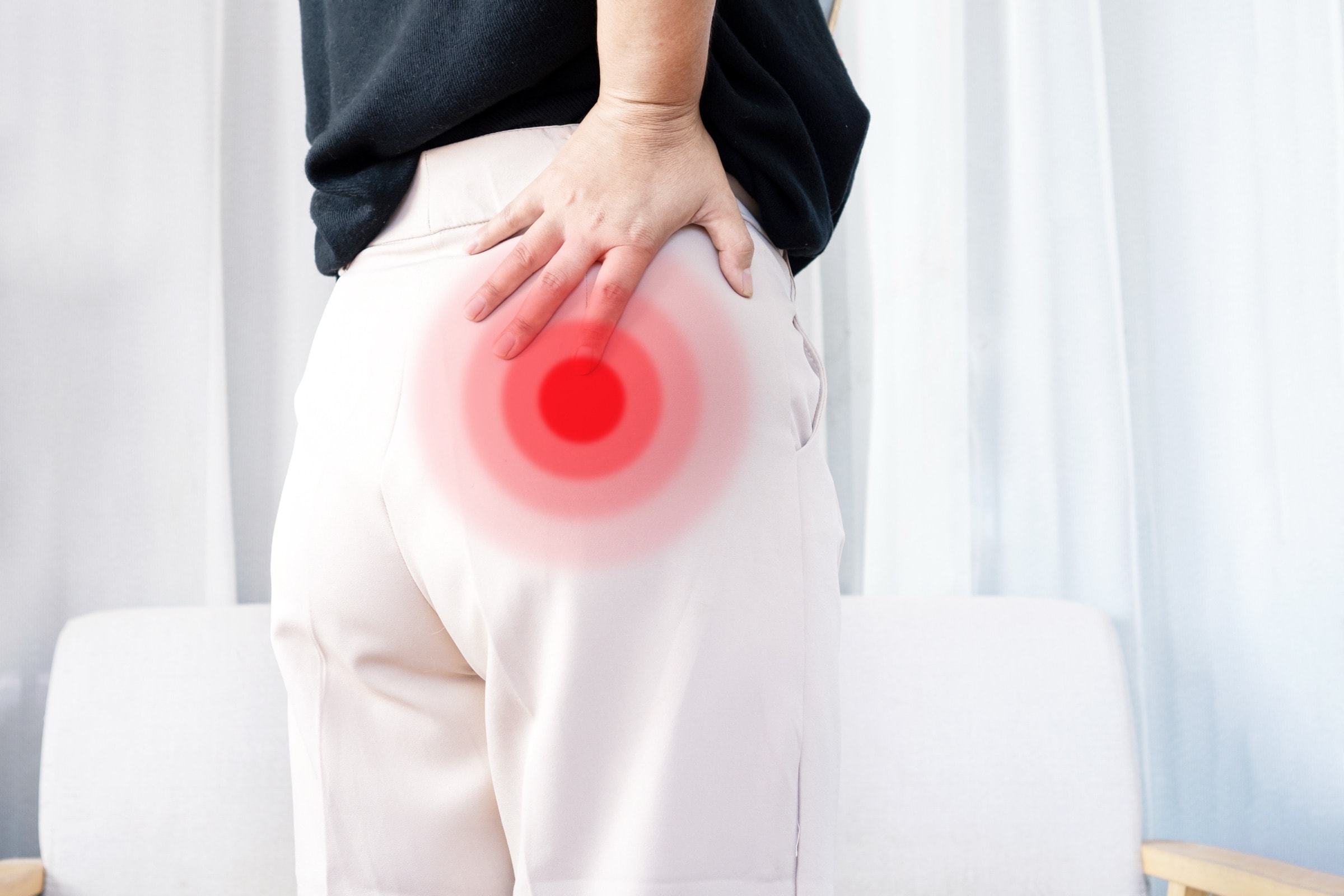 Hand pressed on the buttock where pelvic nerve pain is felt