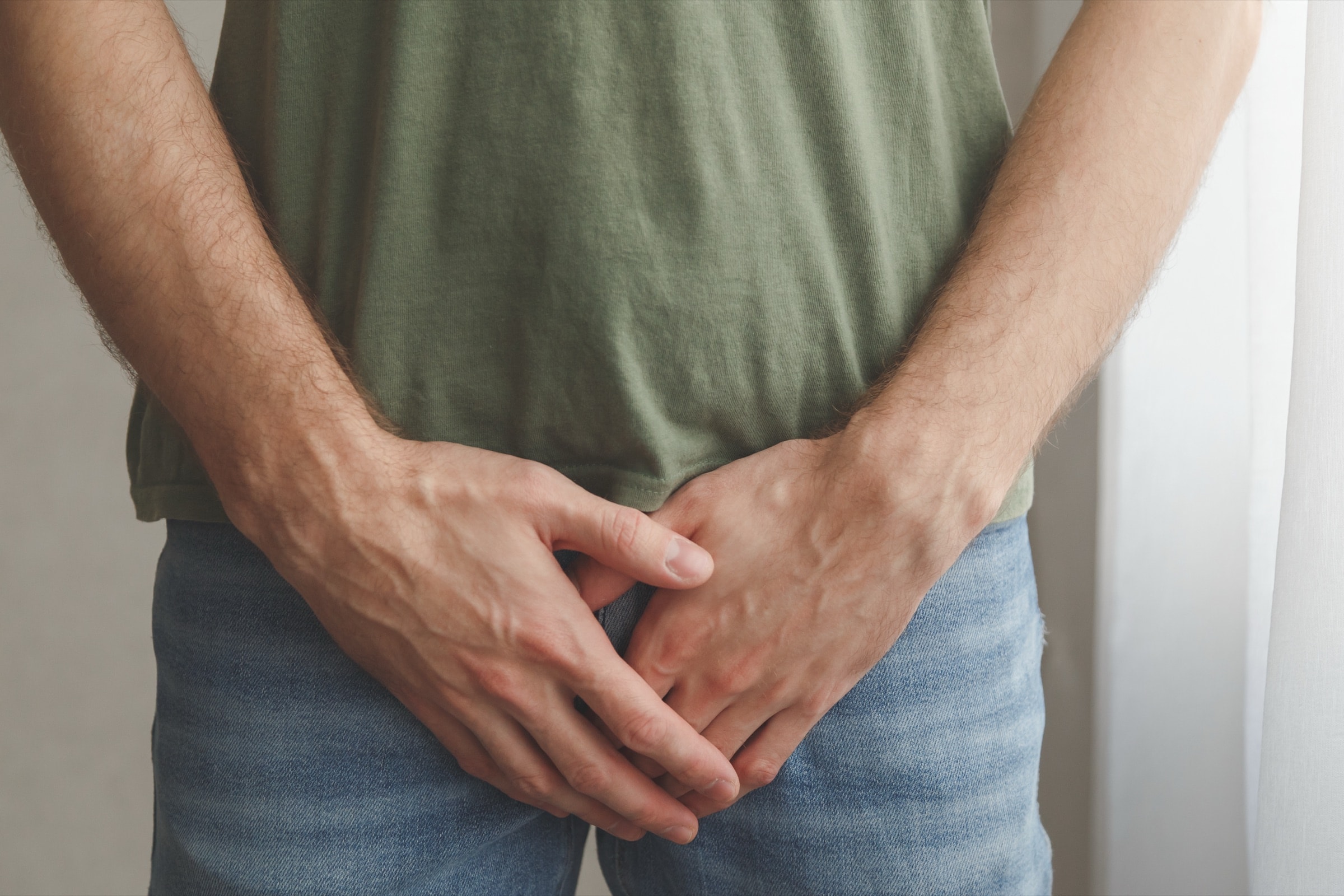 A man holding his hands over his groin