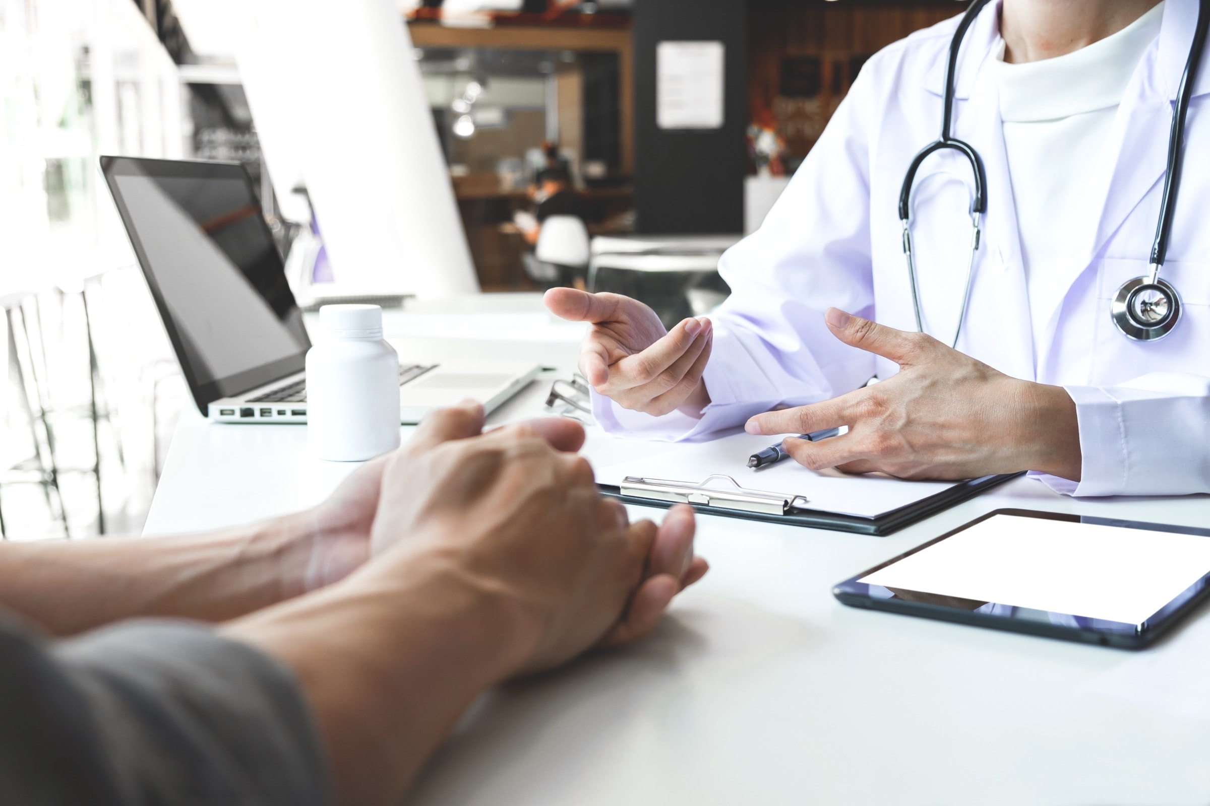 A clinician talking with a patient across a desk